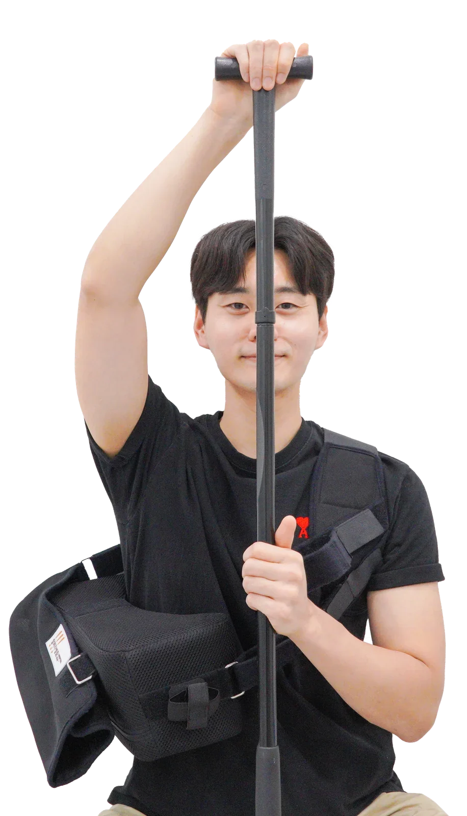 T자 봉을 머리 위로 들어 올려 어깨 가동범위 운동을 하는 모습