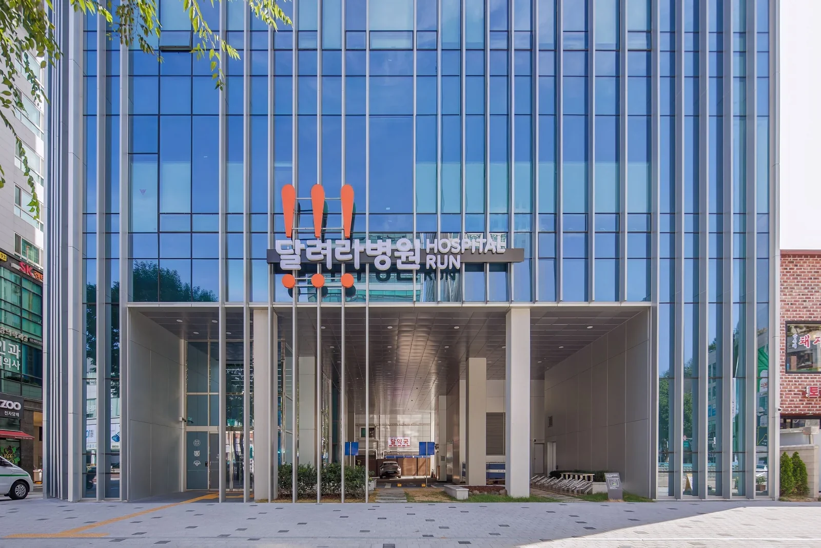 달려라병원 1층 출입구 정면. 느낌표 로고와 달려라병원 간판 아래 출입구가 보인다