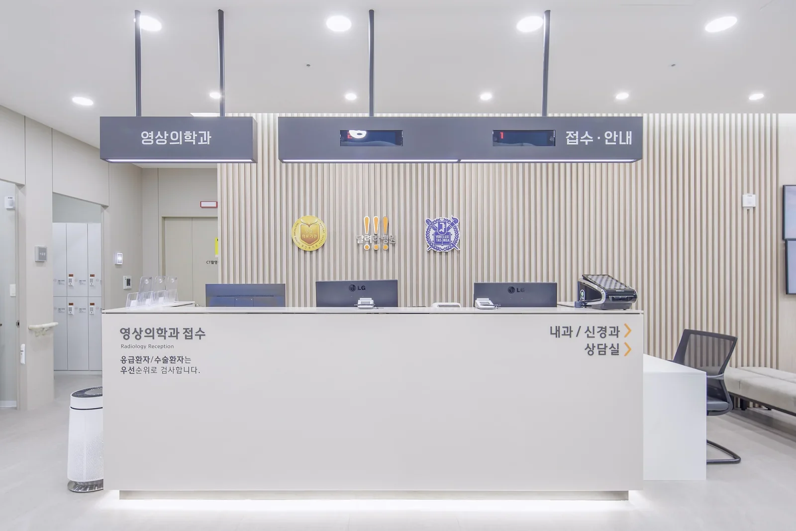 원목 루버 벽에 병원 로고가 붙은 영상의학과 접수대