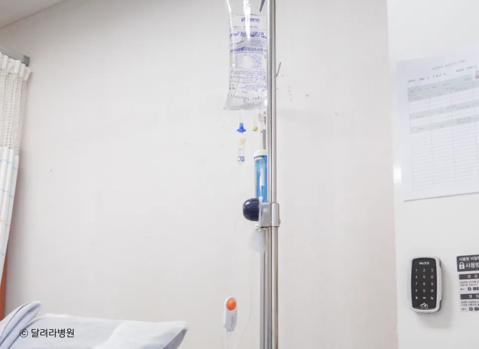 병실 수액 걸이에 매달린 통증조절 주사(PCA). 파란 약통과 주황색 추가 투여 버튼이 수액 줄에 연결된 모습